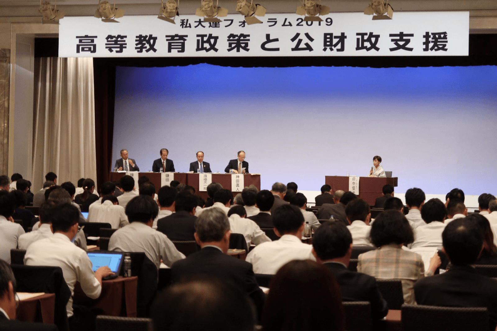 私大連フォーラム2019「高等教育政策と公財政支援」の会場。壇上の登壇者を大勢の参加者が聴いている様子。