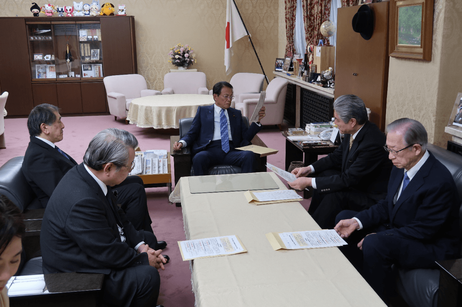 財務大臣室で私大連の役員が財務大臣に制度上の課題を説明している様子。