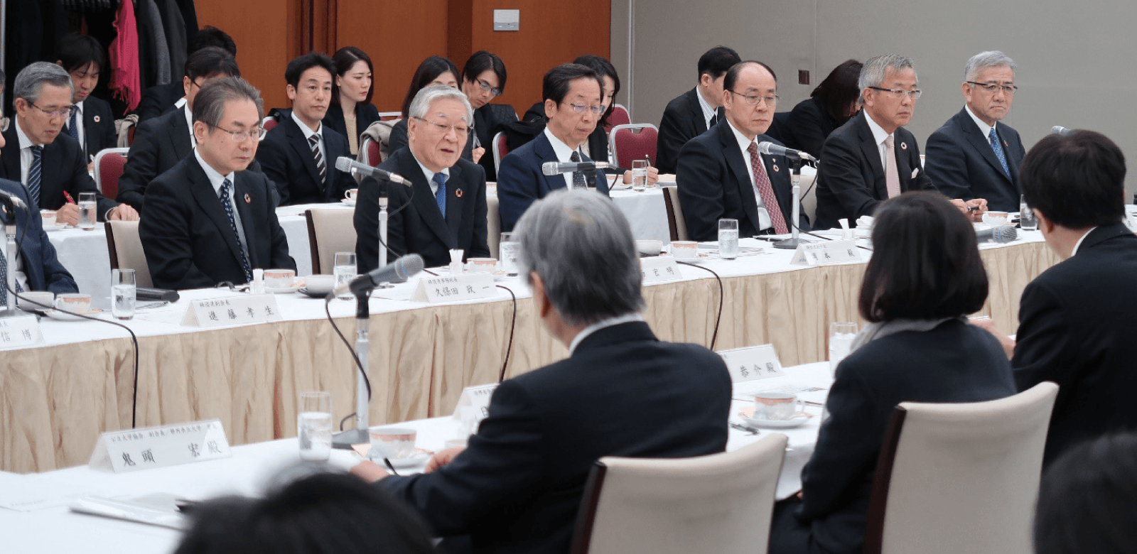 産学協議会の発足式で、大学と産業界の関係者が並ぶ会場の様子。