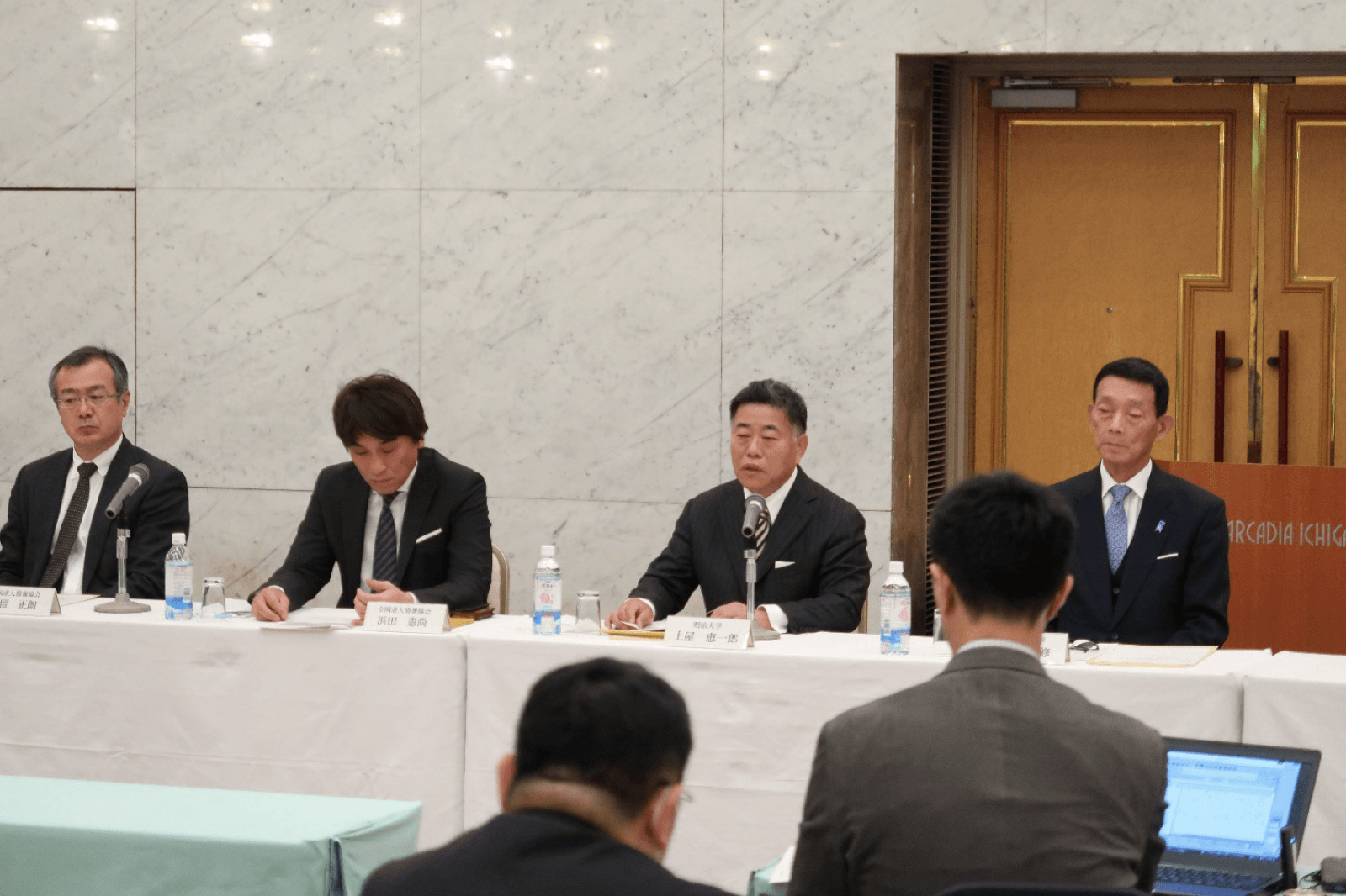 記者会見の会場で就職情報団体の関係者と私大連の役員が並んで着席している様子。