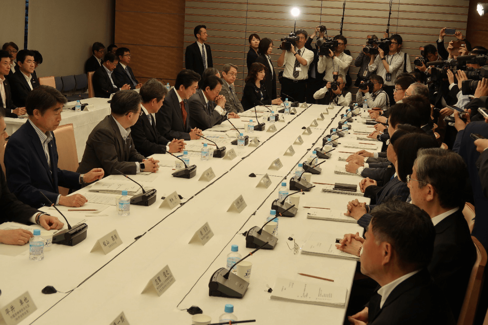 未来投資会議の会場で、私大連の常務理事が資料を手に説明している様子。