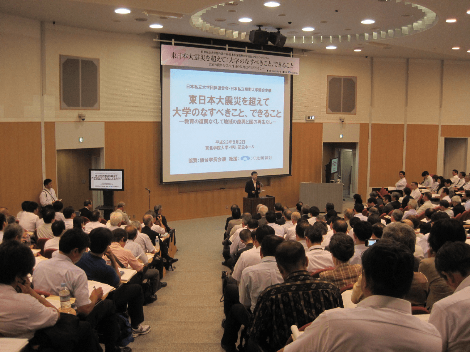 シンポジウム会場で登壇者が発表している様子。